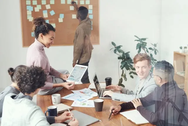 people collaborating around a table for conference room lighting