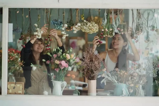 two people creating a floral window display for creative retail display ideas