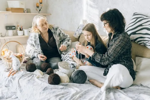 two women and a girl working on a crochet project for crochet coasters