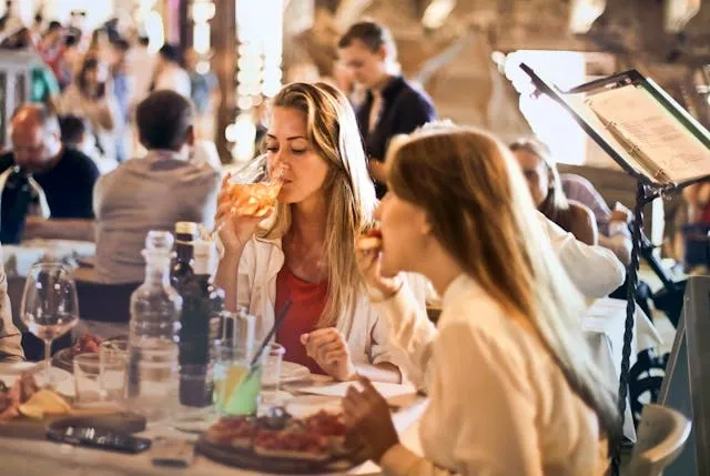 two women dining in a restaurant for how many people can sit at a 8 foot table