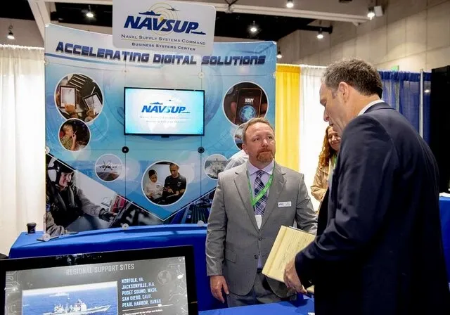 two men talking at a trade show booth for how to stand out at a trade show