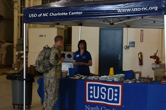 a us army soldier talking to a woman at a booth for designing a trade show booth