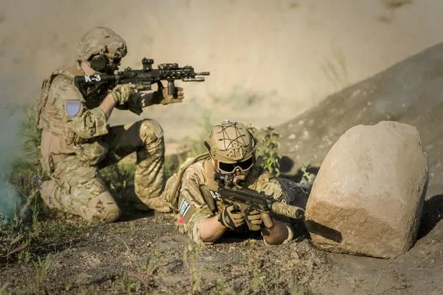 two soldiers crouched near a rock holding rifles for coolest military patches