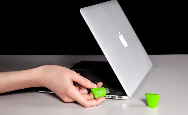 someone putting a promotional usb drive into a laptop for trade show giveaway ideas