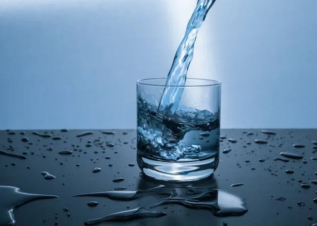 water being poured into a glass surrounded by condensation for coasters that dont stick to glass