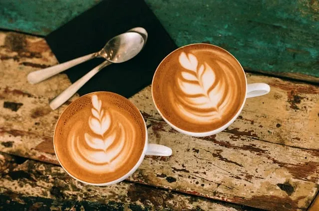 two cups of coffee on a wooden table for coffee coaster ideas