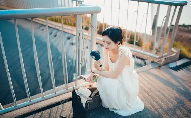 a woman using a portable fan outdoors for can you bring a fan on a plane