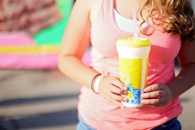 a woman holding a colorful plastic tumbler for how to make custom tumblers