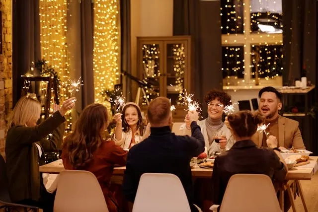 people holding sparklers around a dining table for how many people can sit at a 6-foot table