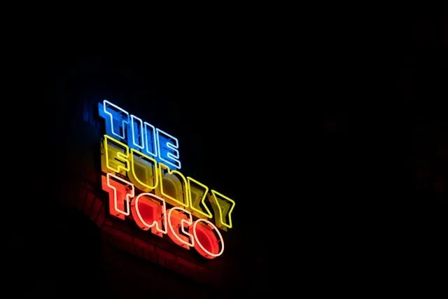 a colorful neon light that reads the funky taco for outdoor business sign ideas