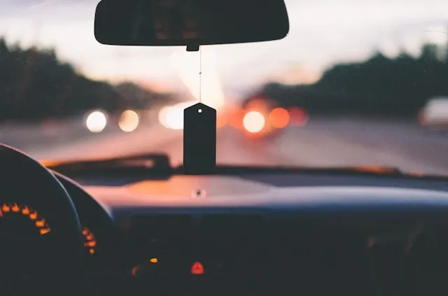 a view looking out the front window of a car at dusk for best car air freshener