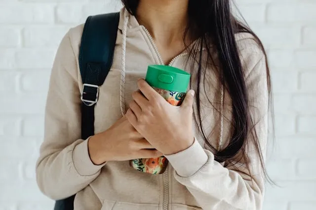 a woman holding a green travel mug for best travel coffee mug a woman holding a green travel mug for best travel coffee mug