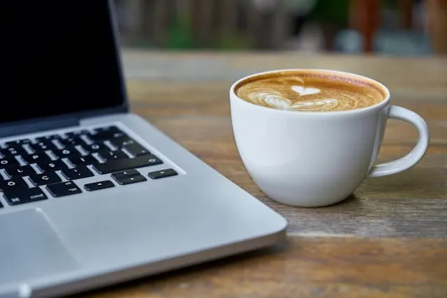 a latte beside a laptop for mug shapes a latte beside a laptop for mug shapes