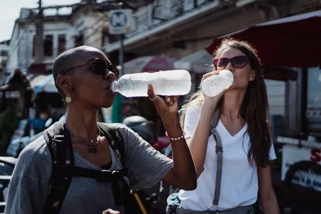 two women with sunglasses drinking water for do neck fans work two women with sunglasses drinking water for do neck fans work