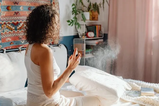 a woman using room spray in her bedroom for are plug-in air fresheners safe a woman using room spray in her bedroom for are plug-in air fresheners safe