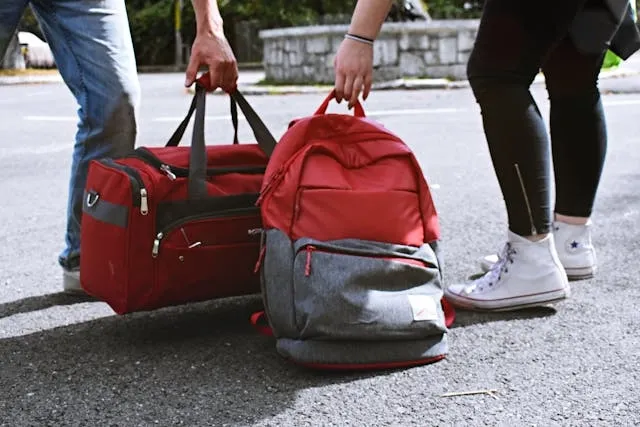 two people carrying a duffel and a backpack for how to wash a duffel bag two people carrying a duffel and a backpack for how to wash a duffel bag